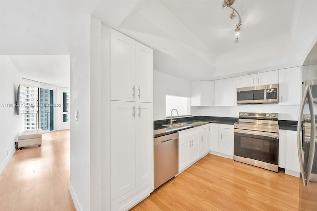 kitchen with light wood-type flooring, white cabinetry, sink, and appliances with stainless steel finishes