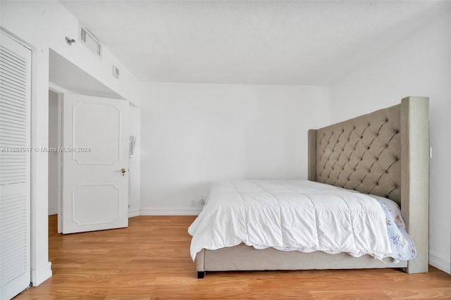 bedroom with wood-type flooring and a textured ceiling