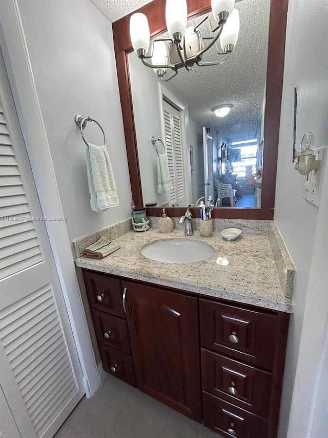 bathroom featuring a textured ceiling, vanity, and a chandelier