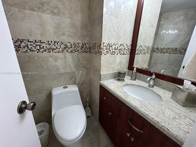 bathroom featuring tile walls, vanity, and toilet