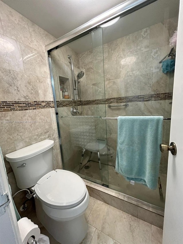 bathroom with walk in shower, toilet, and tile walls