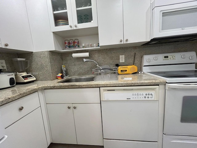 kitchen with white appliances, sink, and white cabinets