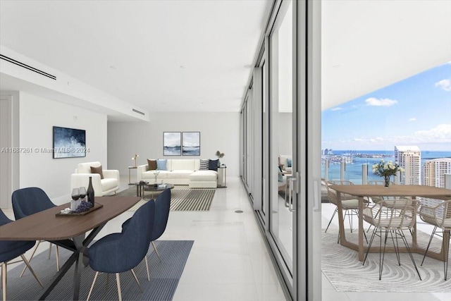 dining room featuring plenty of natural light, a water view, and light tile patterned floors