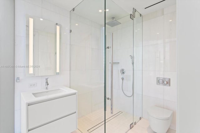 bathroom featuring a shower with shower door, vanity, toilet, and tile walls