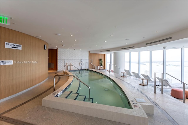 view of pool with a jacuzzi and a water view