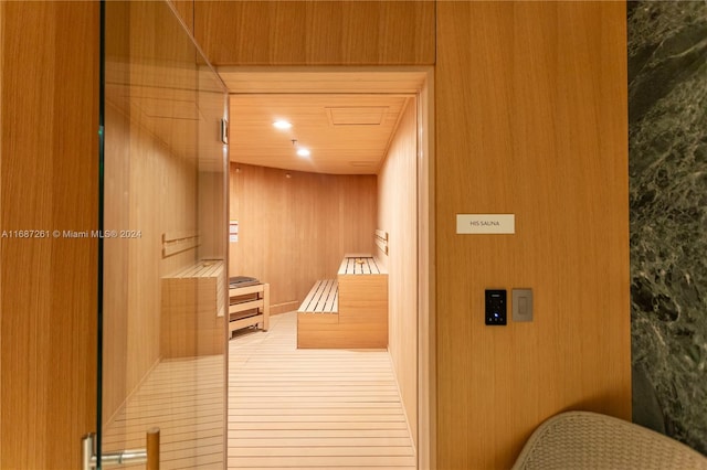 view of sauna with hardwood / wood-style flooring and wooden walls