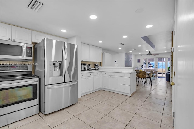 kitchen featuring appliances with stainless steel finishes, light tile patterned floors, ceiling fan, and white cabinets