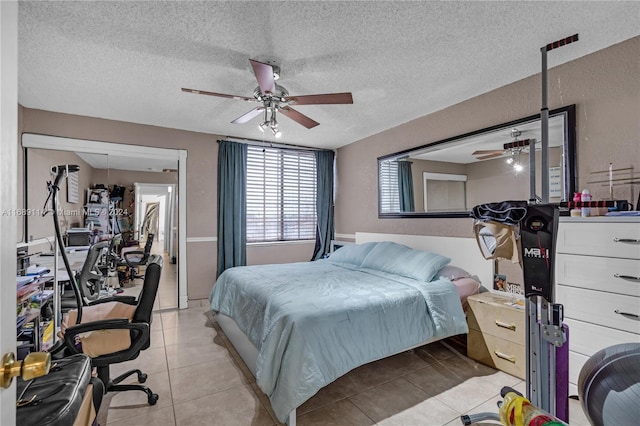 bedroom featuring light tile patterned flooring, a textured ceiling, ceiling fan, and a closet