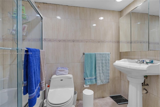 full bathroom featuring tile walls, tile patterned floors, enclosed tub / shower combo, sink, and toilet