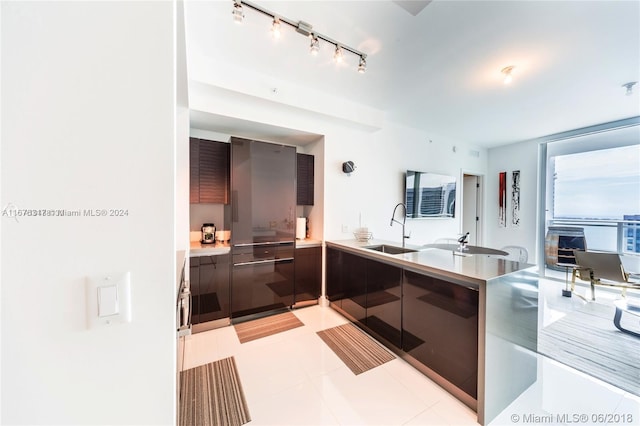 kitchen featuring kitchen peninsula, sink, and track lighting