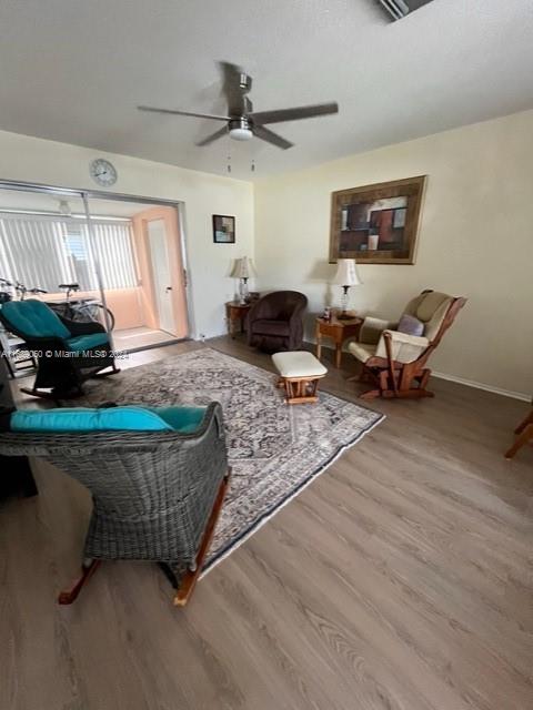 living room featuring hardwood / wood-style floors and ceiling fan