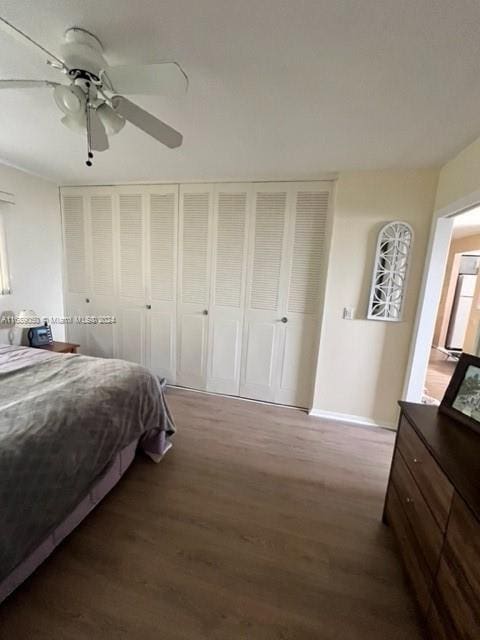 bedroom with ceiling fan, dark hardwood / wood-style floors, and a closet