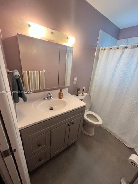 bathroom featuring tile patterned flooring, curtained shower, vanity, and toilet