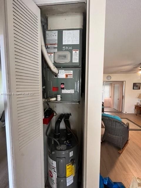 utility room featuring water heater and heating unit