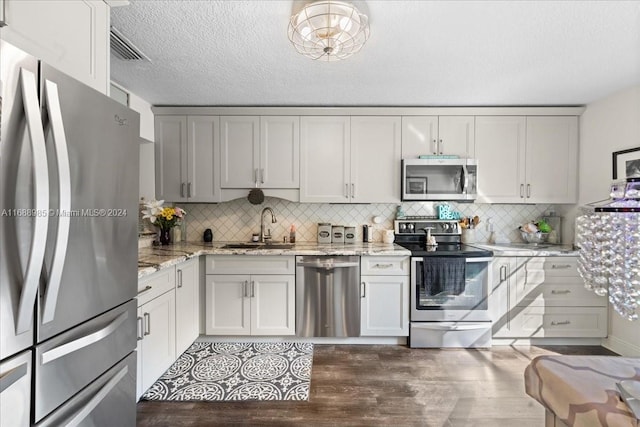 kitchen with dark hardwood / wood-style floors, sink, backsplash, and appliances with stainless steel finishes