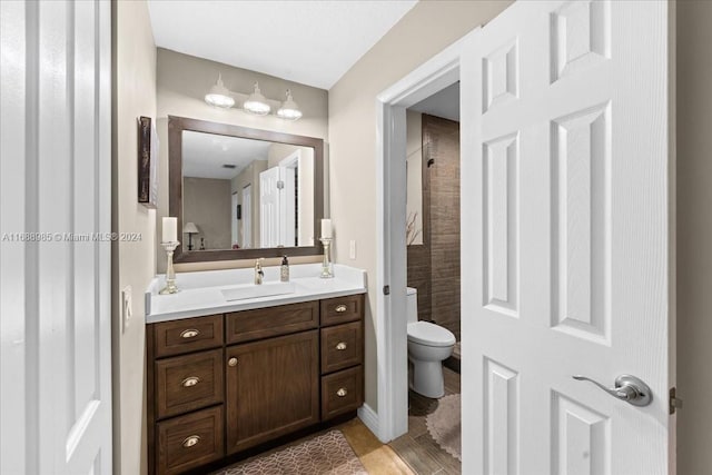 bathroom with toilet, vanity, and hardwood / wood-style flooring