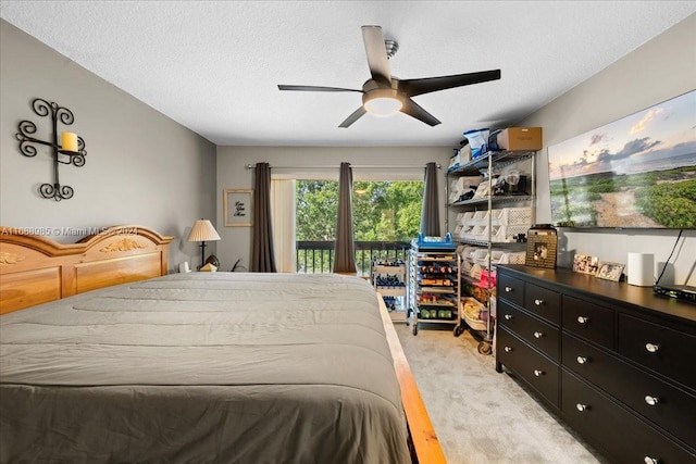 bedroom featuring access to outside, light hardwood / wood-style floors, a textured ceiling, and ceiling fan