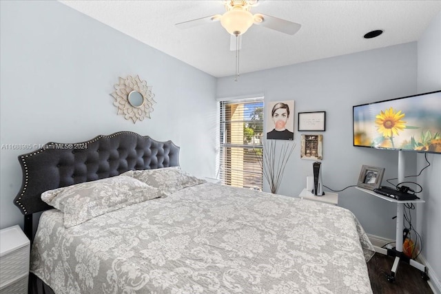 bedroom with dark wood-type flooring, a textured ceiling, and ceiling fan