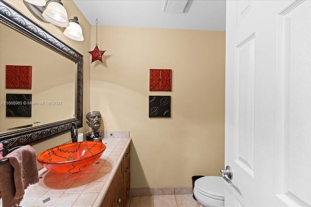 bathroom with tile patterned flooring, vanity, and toilet