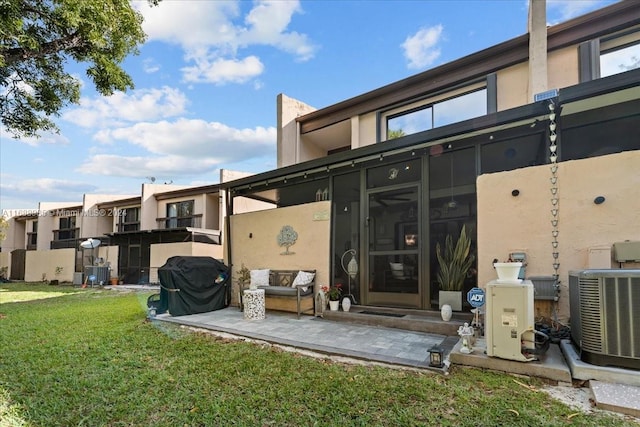 back of house featuring a lawn and central AC unit