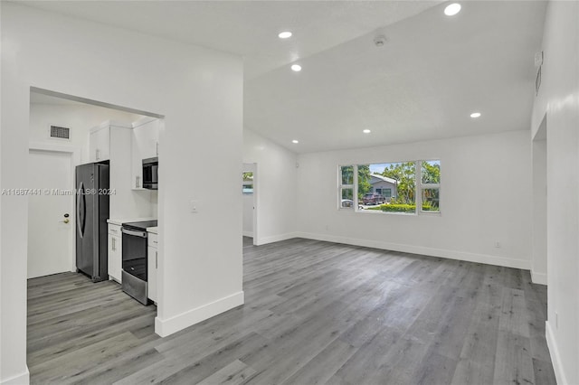 unfurnished living room with light hardwood / wood-style floors and vaulted ceiling