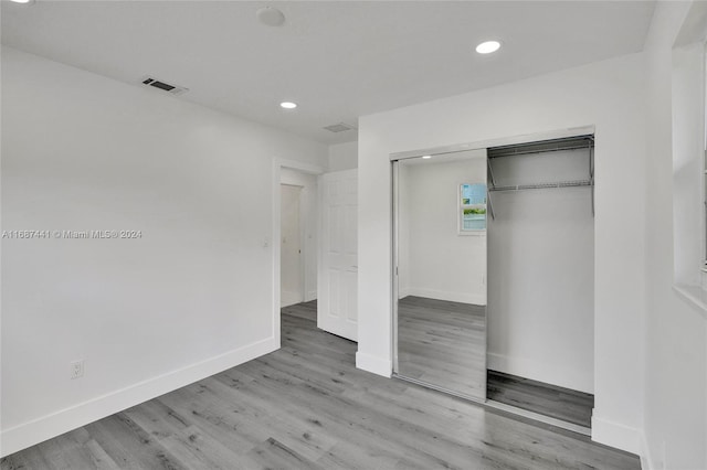 unfurnished bedroom featuring a closet and hardwood / wood-style floors