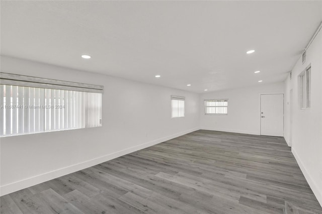 empty room with wood-type flooring and lofted ceiling