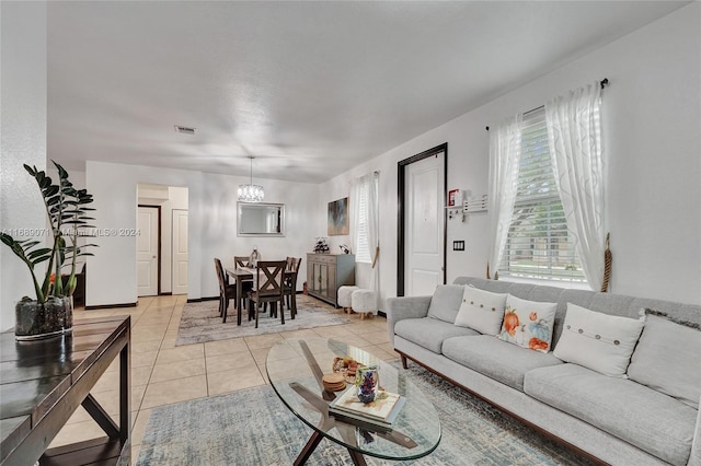 living room with light tile patterned floors and an inviting chandelier