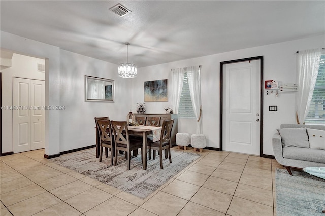 dining area featuring light tile patterned flooring and a chandelier