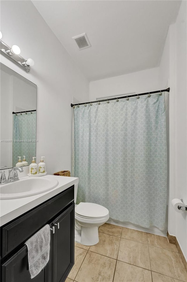 bathroom featuring toilet, vanity, and tile patterned flooring