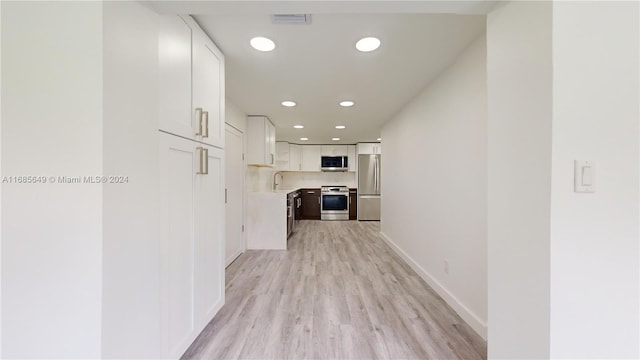 hallway featuring light hardwood / wood-style flooring and sink