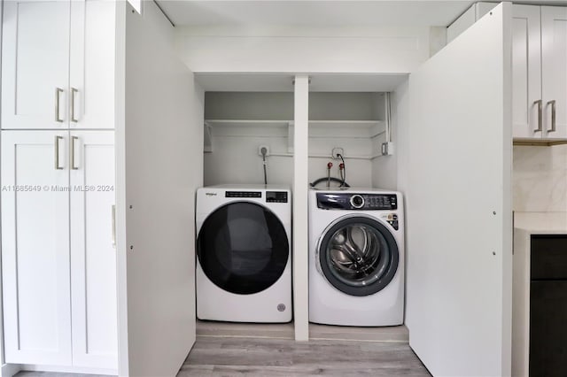 laundry area with light wood-type flooring and separate washer and dryer