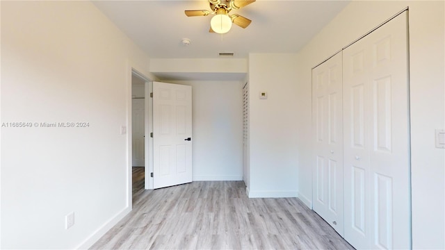 unfurnished bedroom featuring ceiling fan, a closet, and light hardwood / wood-style flooring