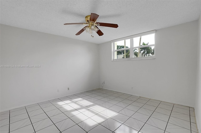 tiled spare room featuring ceiling fan and a textured ceiling