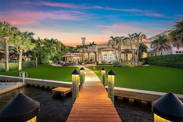 view of dock with a lawn and a gazebo