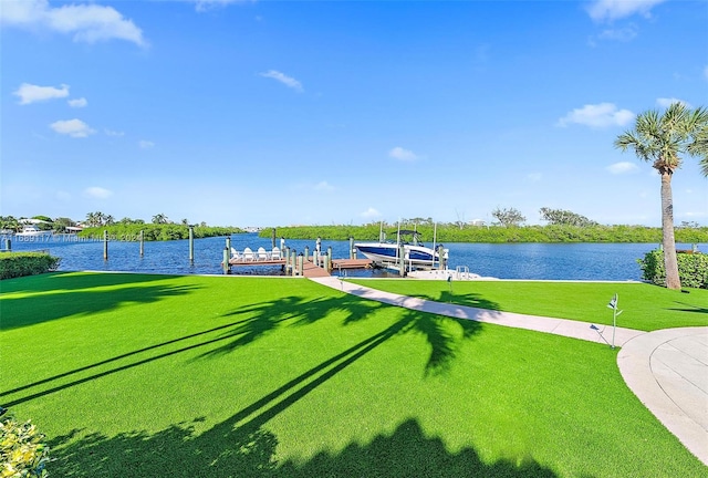 view of home's community featuring a lawn, a water view, and a boat dock