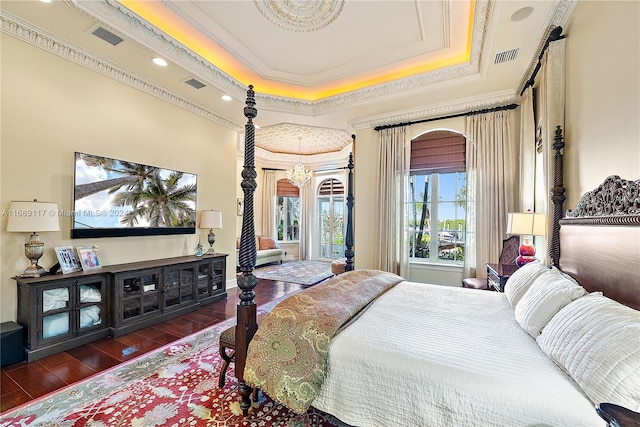 bedroom with ornamental molding, dark hardwood / wood-style floors, and a raised ceiling