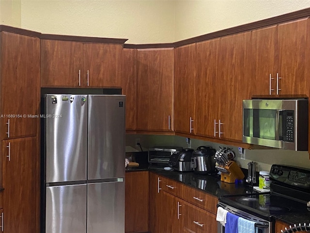 kitchen featuring dark stone countertops and appliances with stainless steel finishes