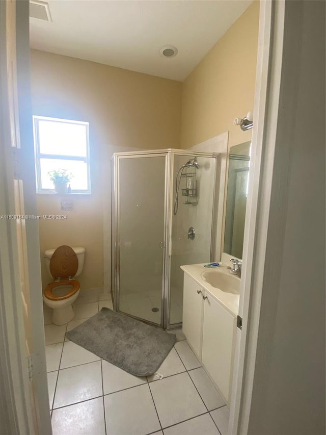 bathroom featuring vanity, walk in shower, tile patterned flooring, and toilet