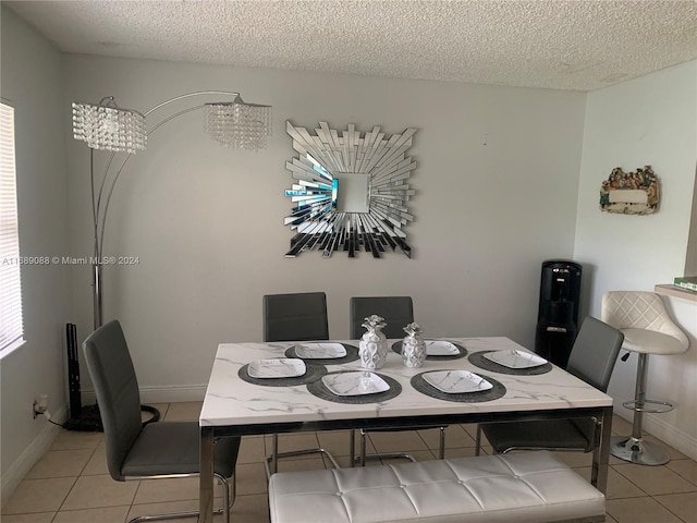 dining room with a textured ceiling and light tile patterned flooring