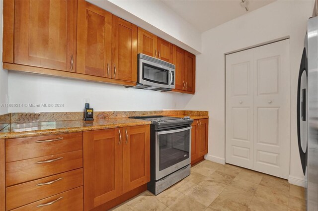 kitchen featuring light stone countertops and appliances with stainless steel finishes