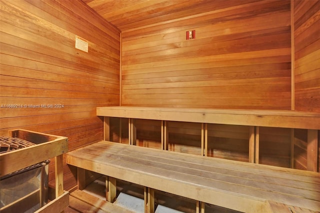 view of sauna featuring wooden ceiling and wood walls