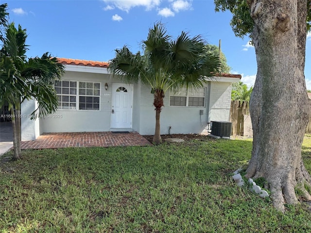 view of front of property featuring central AC and a front yard