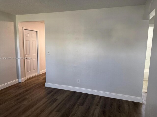 spare room with dark wood-type flooring