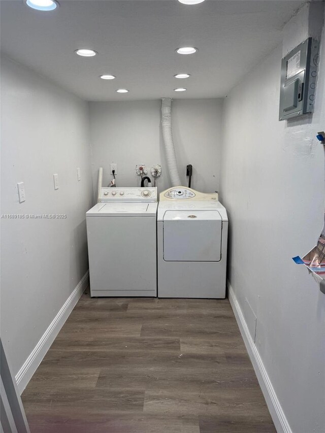 laundry room featuring dark hardwood / wood-style floors, separate washer and dryer, and electric panel