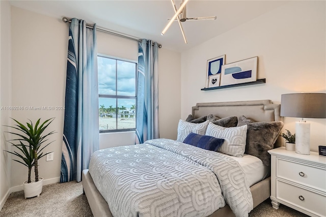 carpeted bedroom featuring an inviting chandelier