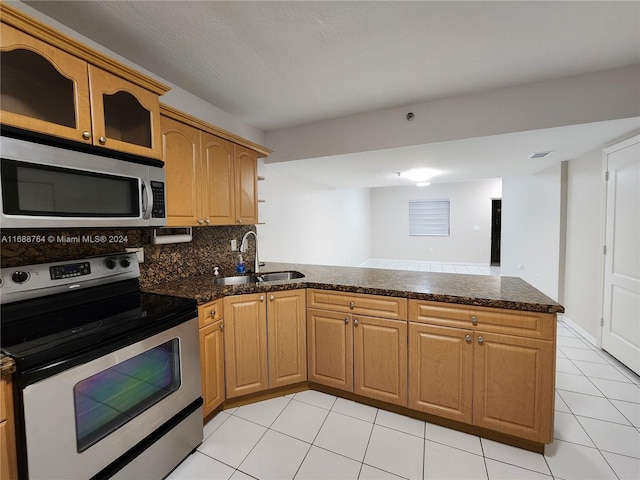 kitchen featuring stainless steel appliances, decorative backsplash, kitchen peninsula, sink, and light tile patterned floors