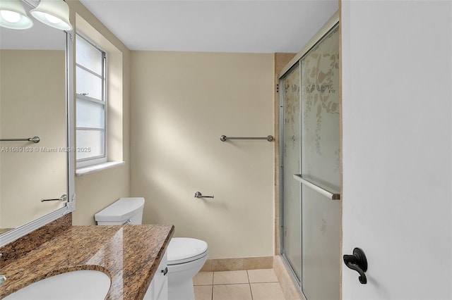 bathroom with vanity, a shower with door, tile patterned floors, and toilet