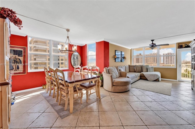 dining space featuring light tile patterned floors, ceiling fan with notable chandelier, and a wall of windows