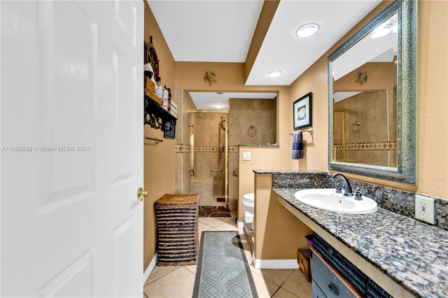 bathroom featuring toilet, vanity, tile patterned floors, and an enclosed shower